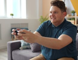 Man intensely focused on playing video games in a comfortable living room setting.