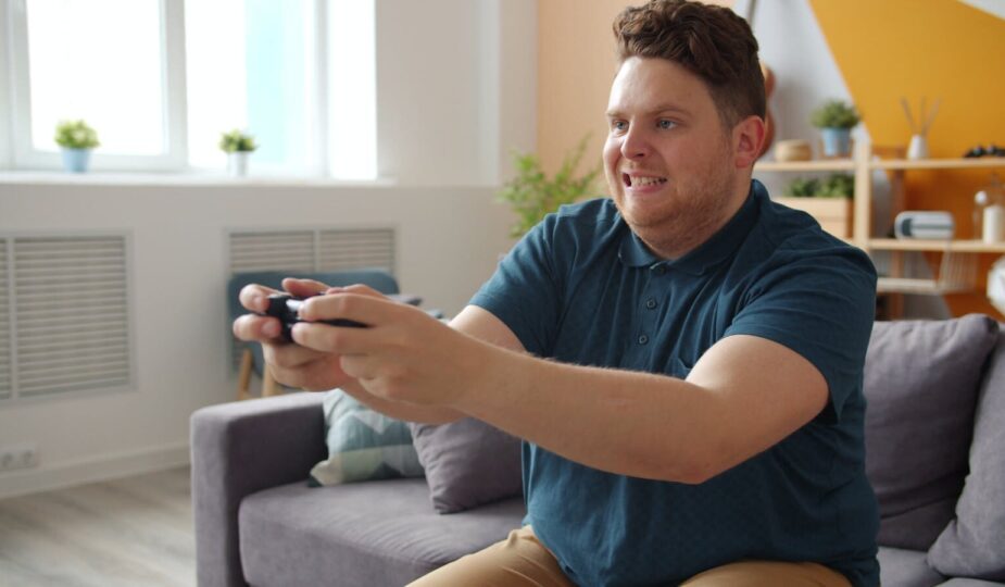 Man intensely focused on playing video games in a comfortable living room setting.